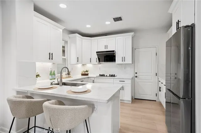 a kitchen with white cabinets and refrigerator