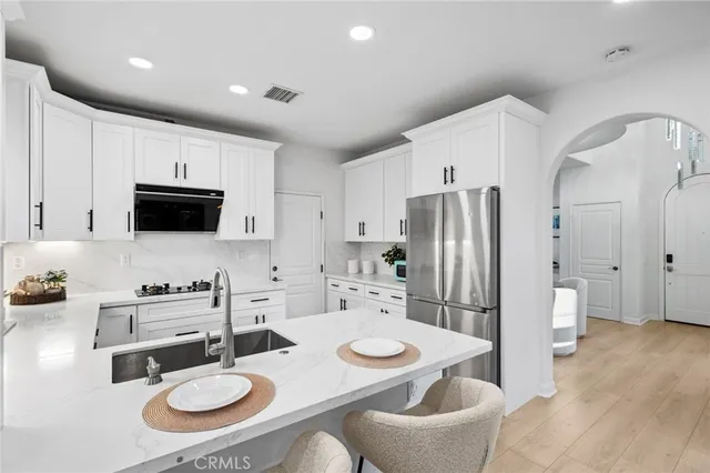 a kitchen with granite countertop a sink a stove and cabinets