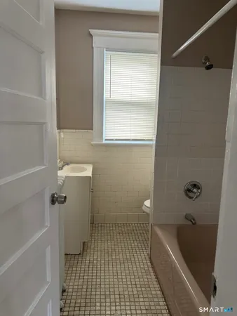 a bathroom with a tub a sink and a toilet