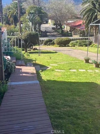 a brick house next to a yard with large trees
