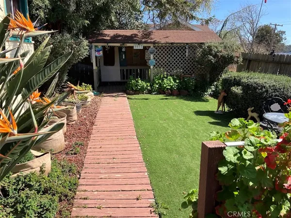 a front view of a house with a yard and potted plants