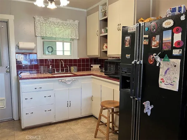 a bedroom with a bed painting on wall and a large window
