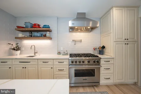 a kitchen with white cabinets and appliances