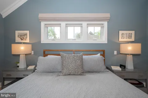 a bedroom with a bed and a television on dresser