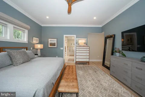 a bedroom with a bed and a flat screen tv on dresser