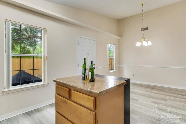 a kitchen with stainless steel appliances a stove a refrigerator cabinets and wooden floor