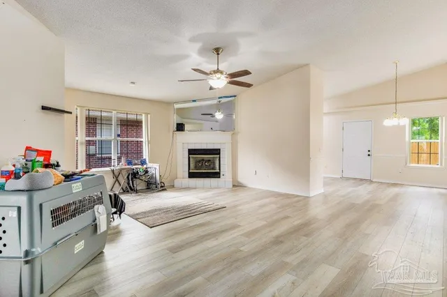 a view of an empty room with a fireplace and a fan