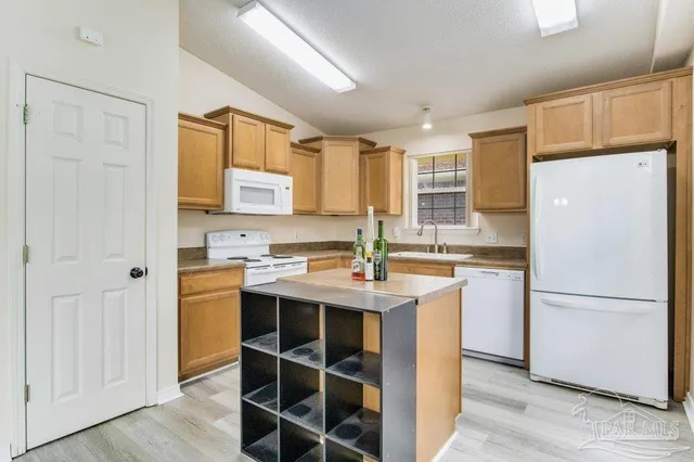 a kitchen with a sink a window and cabinets