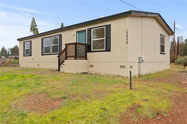 a view of a house with backyard and wooden fence
