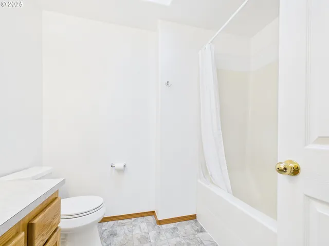a white toilet sitting next to a shower