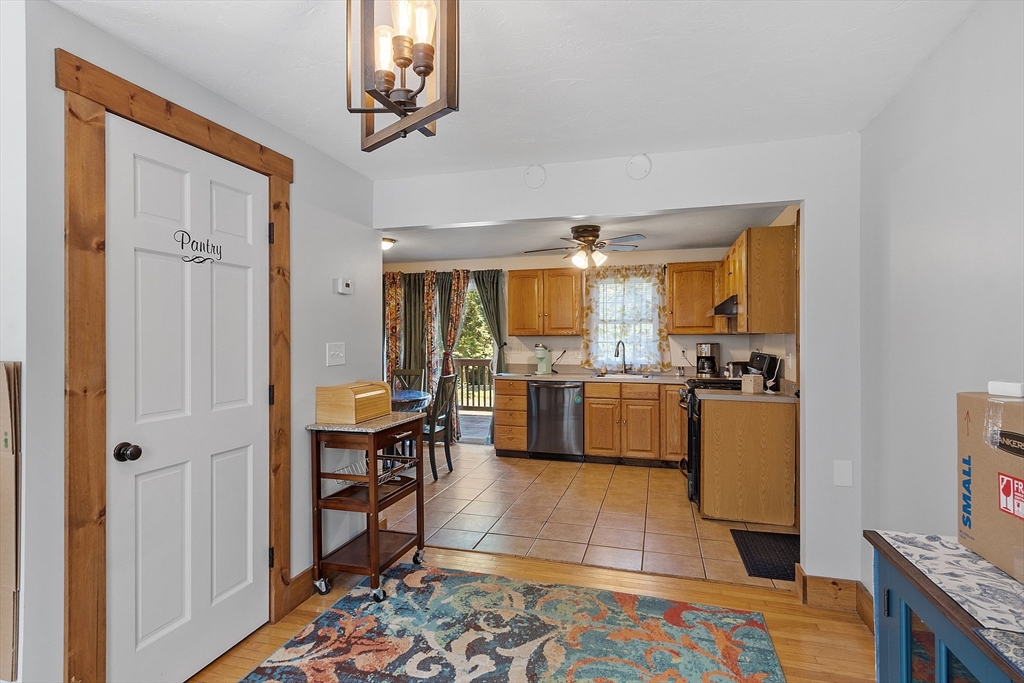 76 Ferin Road Ashburnham, MA 01430 - Photo 13 of 41 a large white kitchen with stainless steel appliances granite countertop a couch and a view of living room