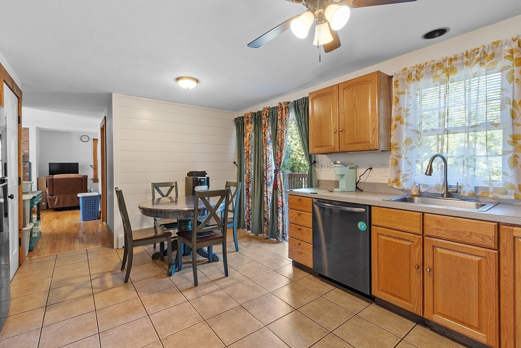 76 Ferin Road Ashburnham, MA 01430 - Photo 7 of 41 a kitchen with stainless steel appliances granite countertop a sink a stove a dining table and chairs with wooden floor