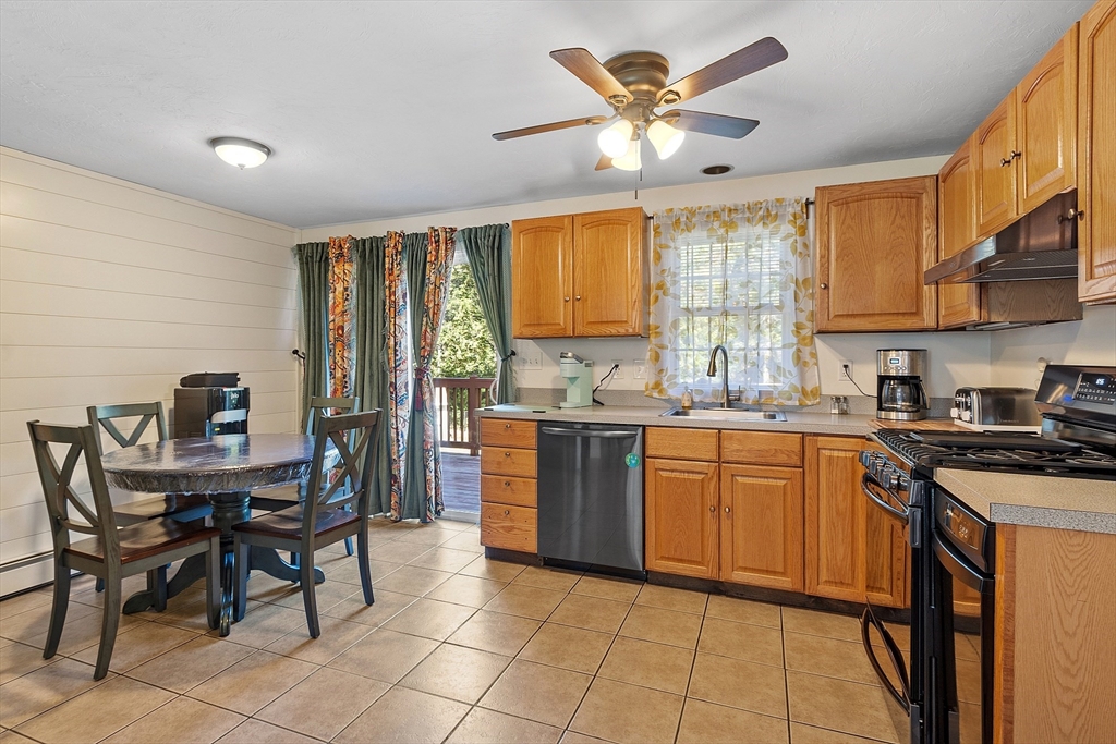 76 Ferin Road Ashburnham, MA 01430 - Photo 8 of 41 a kitchen with stainless steel appliances granite countertop a stove a sink dishwasher a dining table and chairs with wooden floor