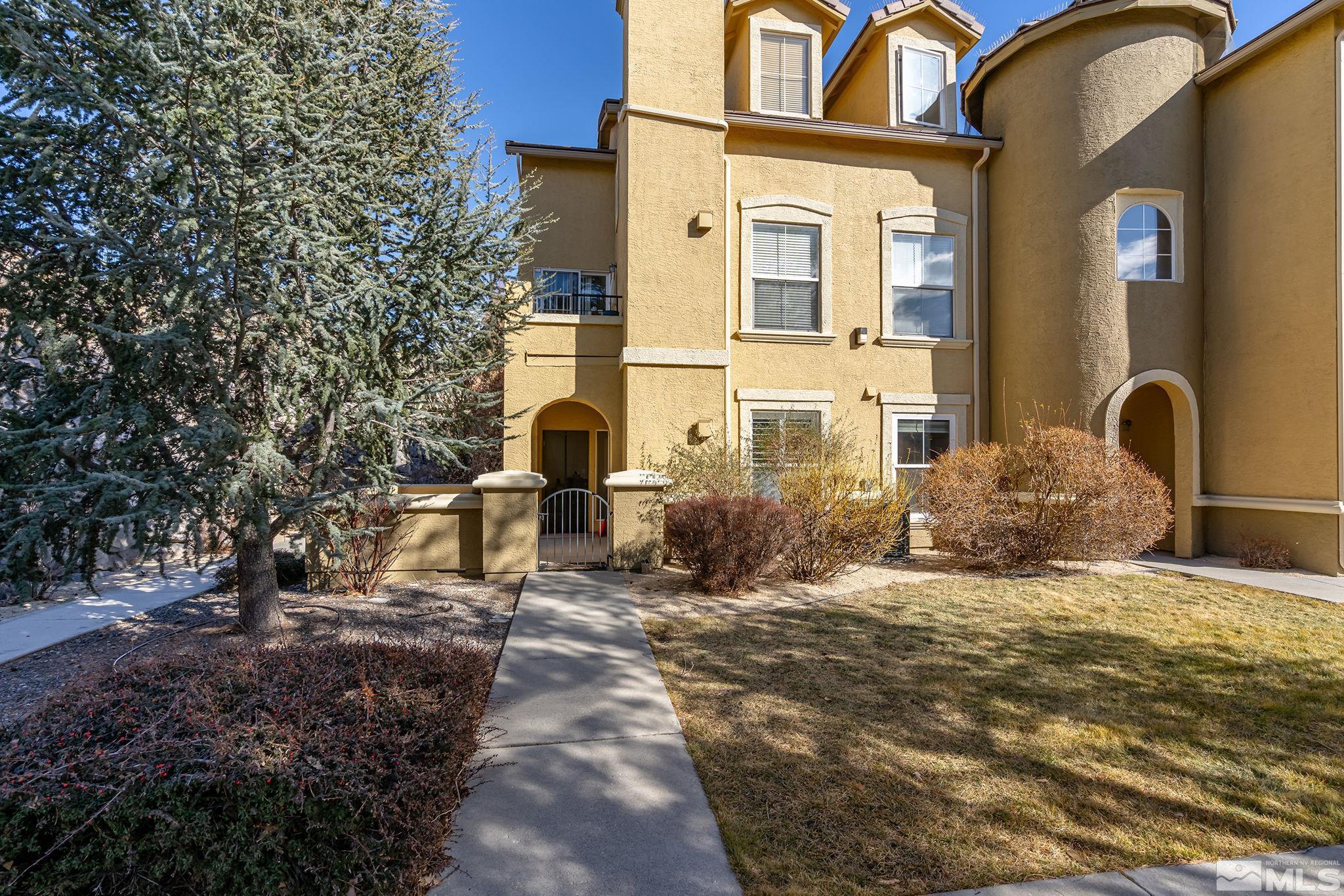 9050 Double R Boulevard, Unit 1211 Reno, NV 89521 - Photo 1 of 20 a view of a brick house with many windows and a tree