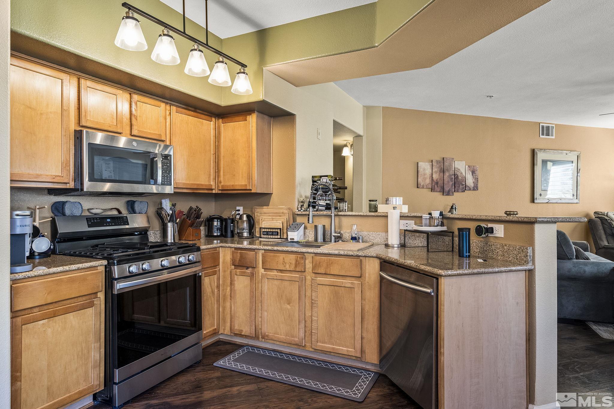 9050 Double R Boulevard, Unit 1211 Reno, NV 89521 - Photo 11 of 20 a kitchen with stainless steel appliances a stove a sink and a microwave