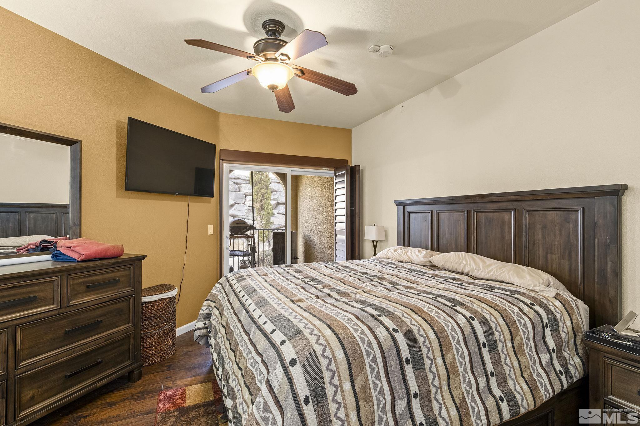 9050 Double R Boulevard, Unit 1211 Reno, NV 89521 - Photo 14 of 20 a bedroom with a bed and a flat screen tv