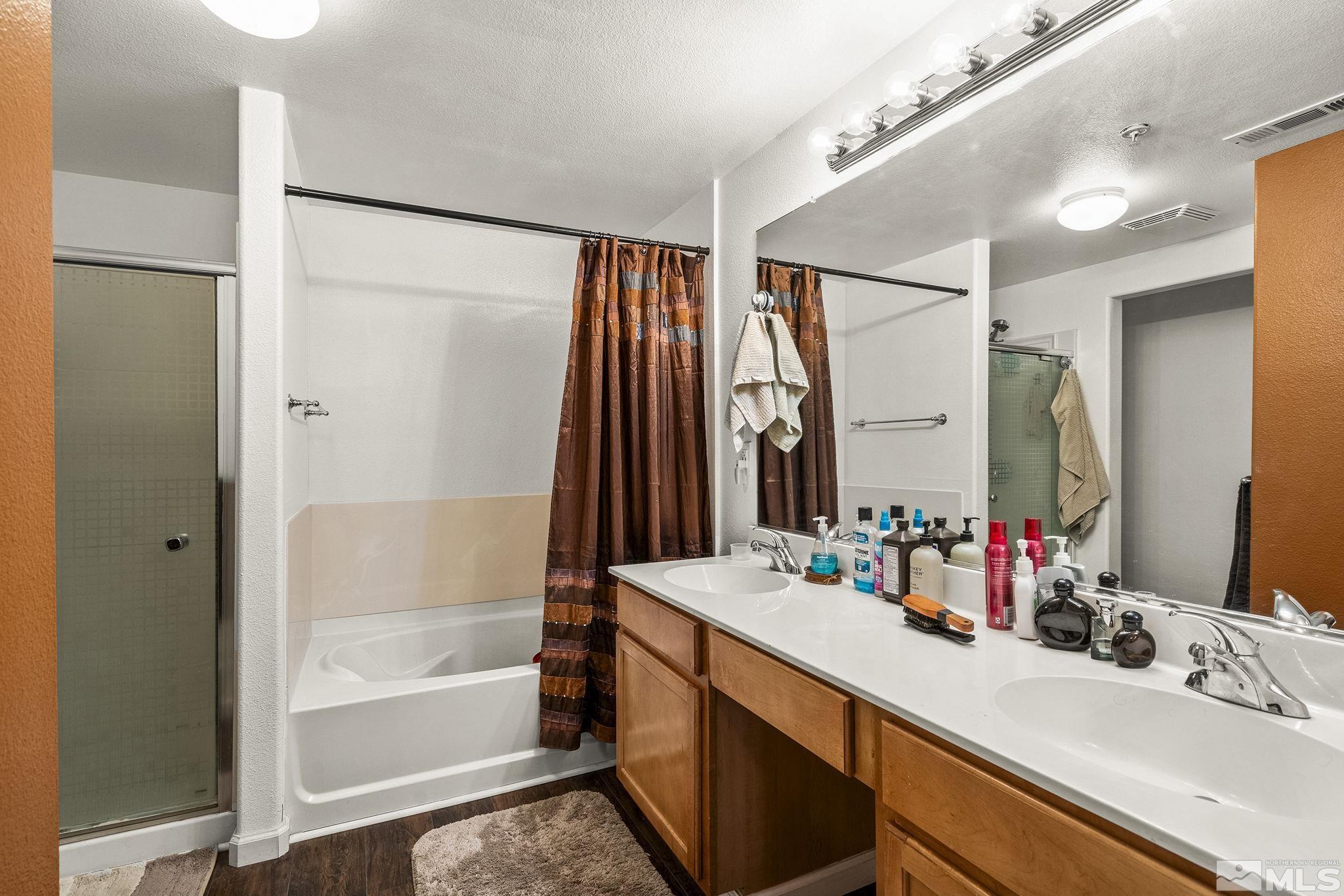 9050 Double R Boulevard, Unit 1211 Reno, NV 89521 - Photo 15 of 20 a bathroom with a double vanity sink mirror and shower