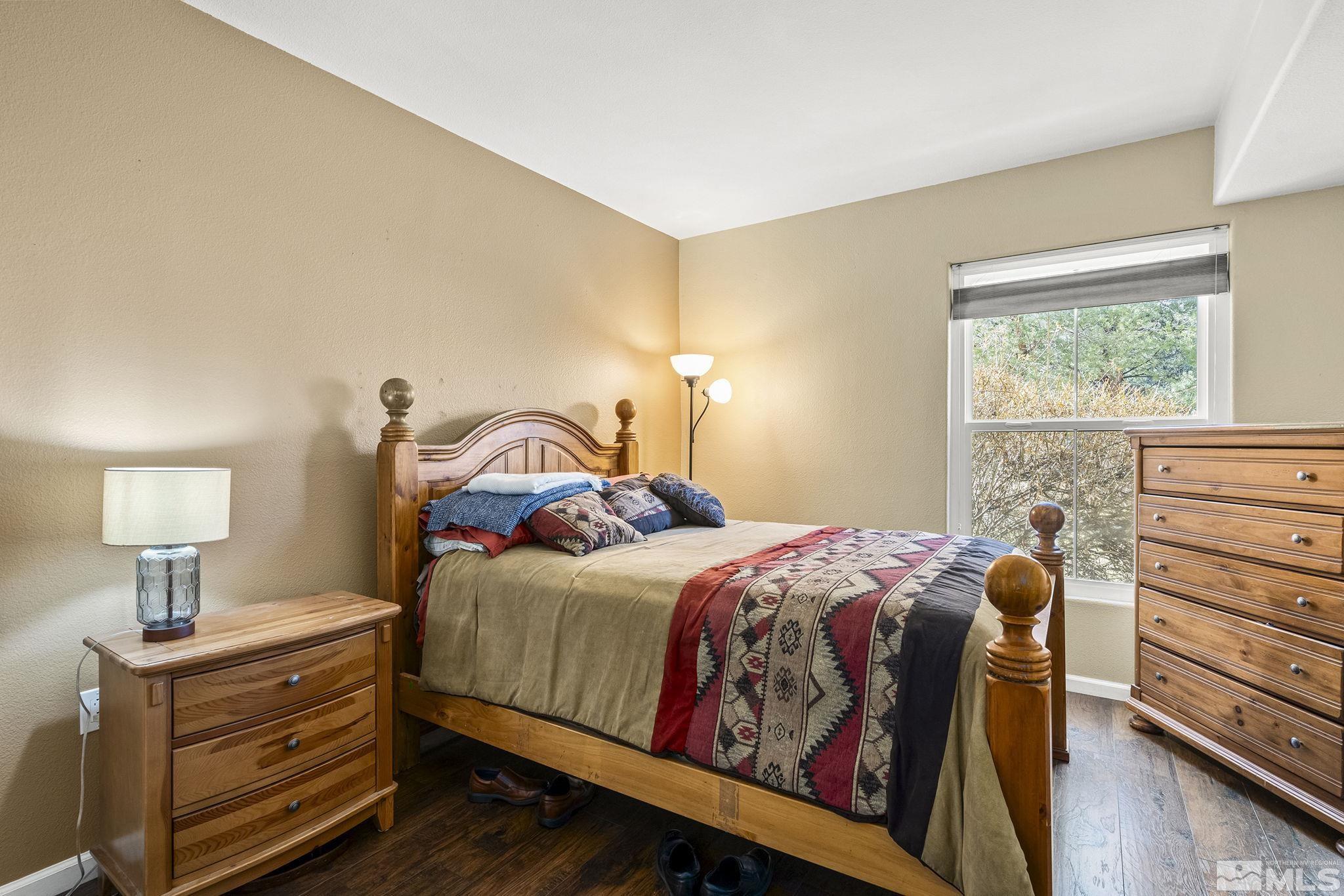 9050 Double R Boulevard, Unit 1211 Reno, NV 89521 - Photo 17 of 20 a bedroom with a bed and a lamp on the dresser