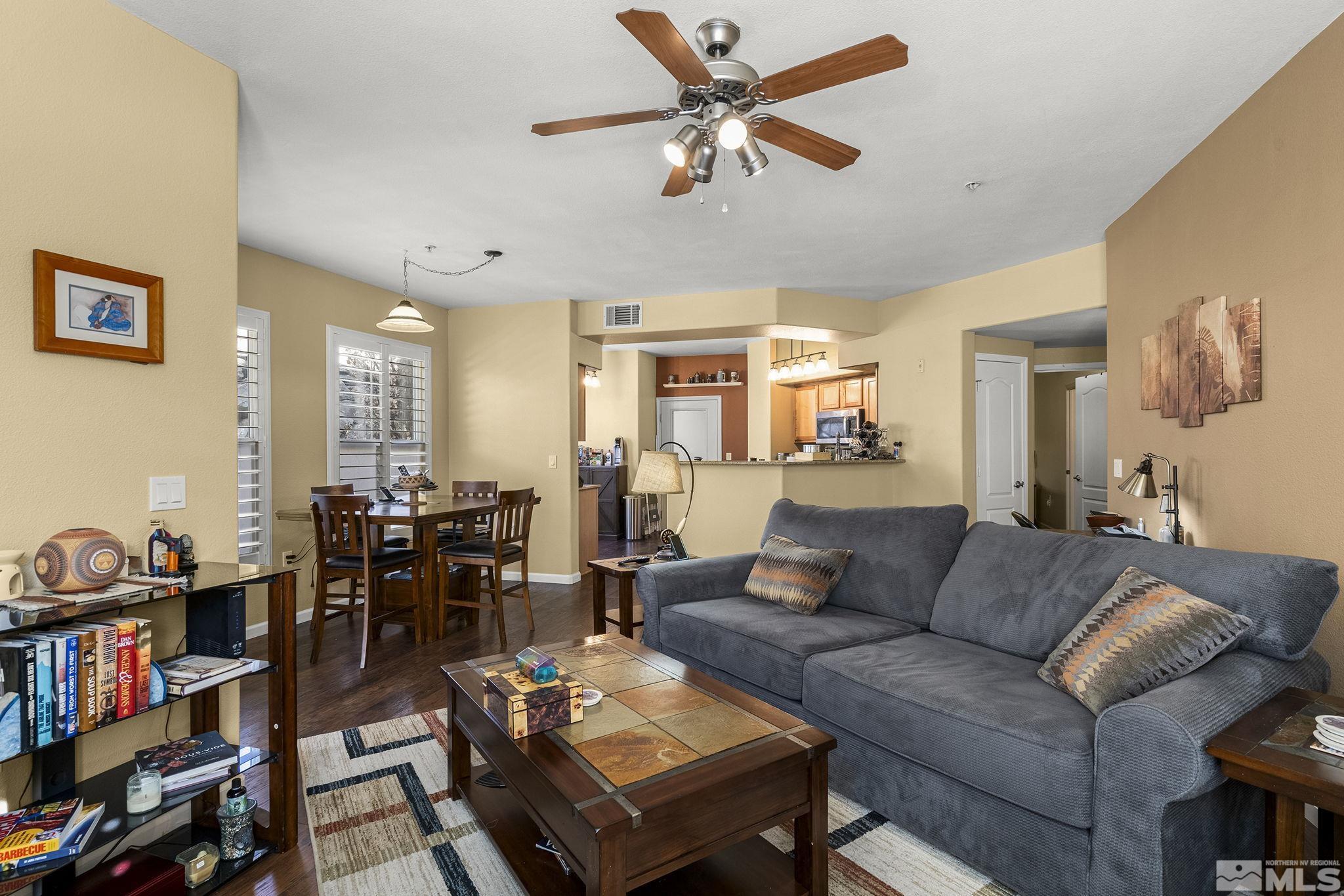 9050 Double R Boulevard, Unit 1211 Reno, NV 89521 - Photo 6 of 20 a living room with furniture a bookshelf and a window