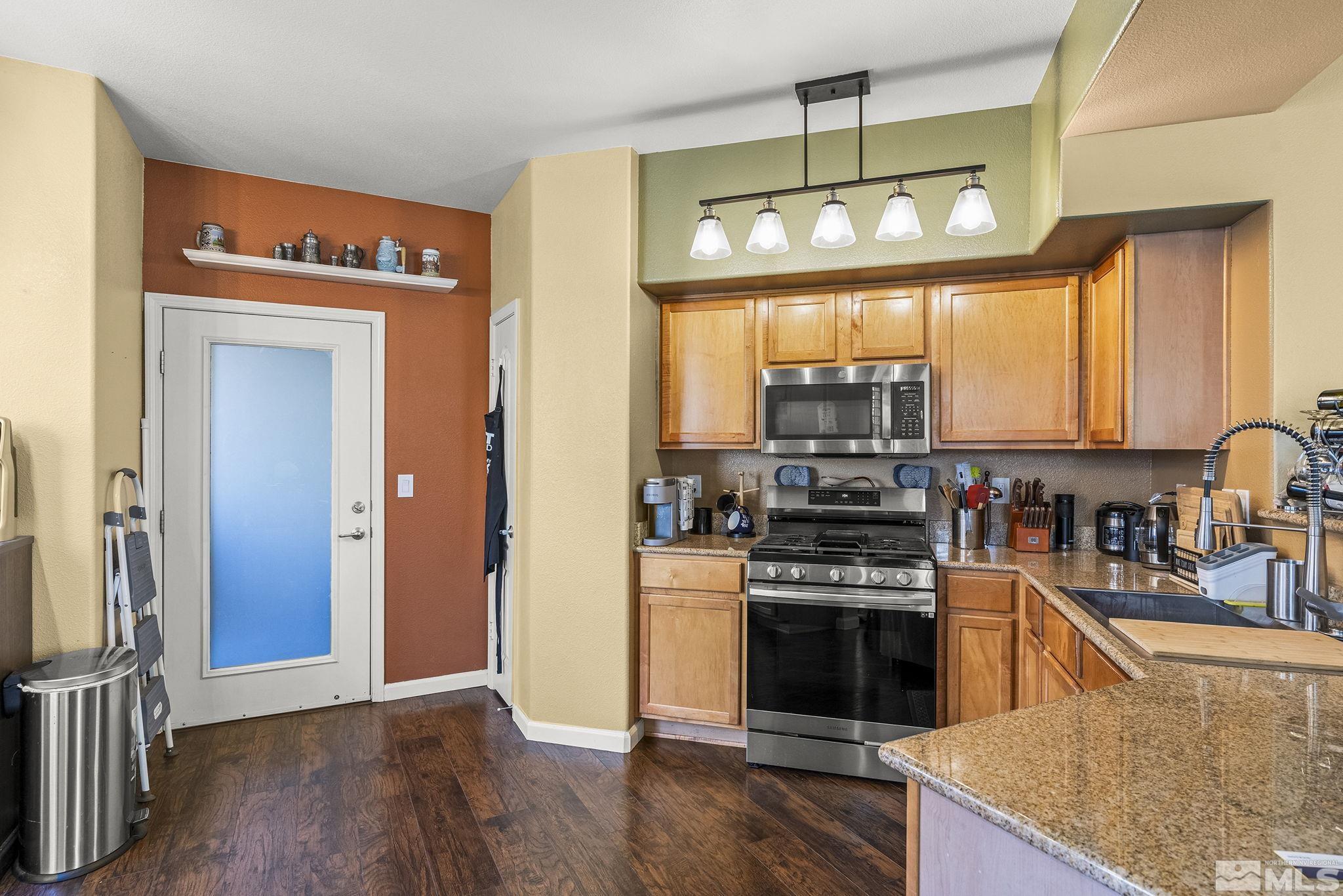 9050 Double R Boulevard, Unit 1211 Reno, NV 89521 - Photo 10 of 20 a kitchen with stainless steel appliances granite countertop a stove a sink and a microwave