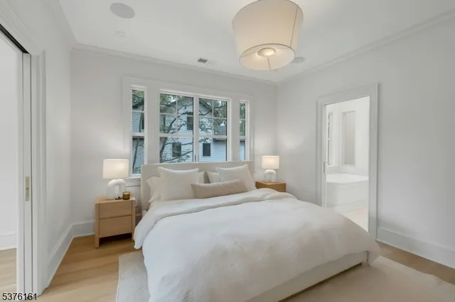 a bedroom with a large bed and a chandelier