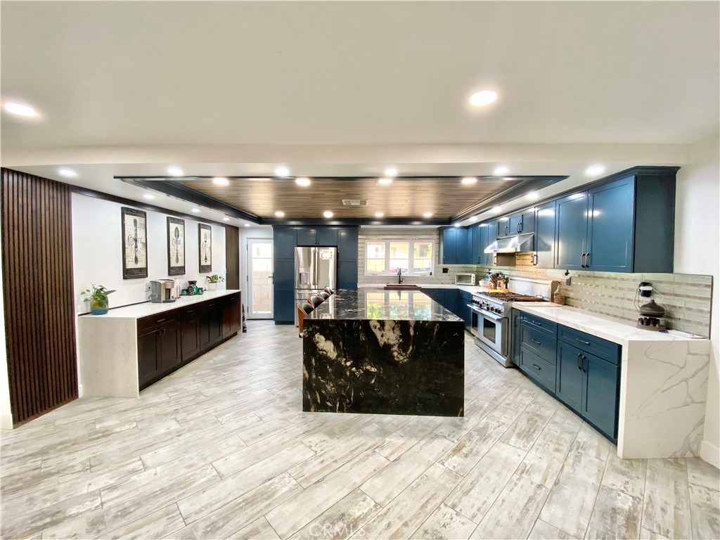 a large white kitchen with a large counter top and stainless steel appliances