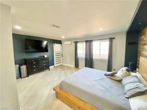 a bedroom with a large bed and a flat screen tv