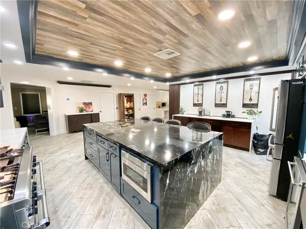 a large kitchen with stainless steel appliances granite countertop a lot of counter space and wooden floors