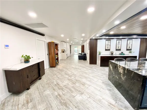 a large kitchen with stainless steel appliances kitchen island a large counter top and a refrigerator