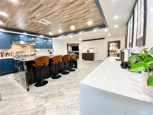 a large room with stainless steel appliances lots of counter space and furniture