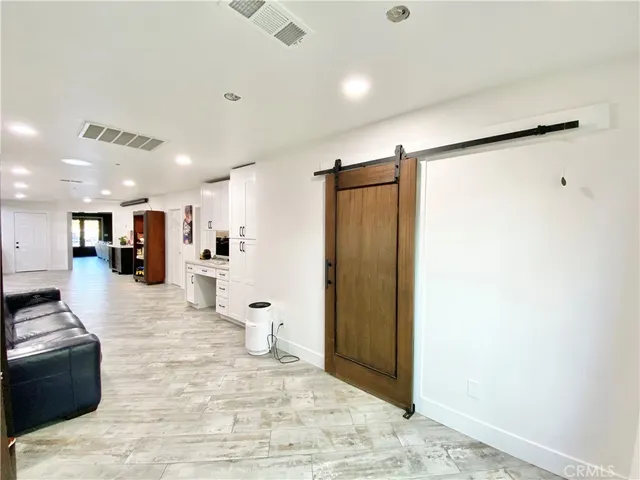 a large white room with a large window and stainless steel appliances