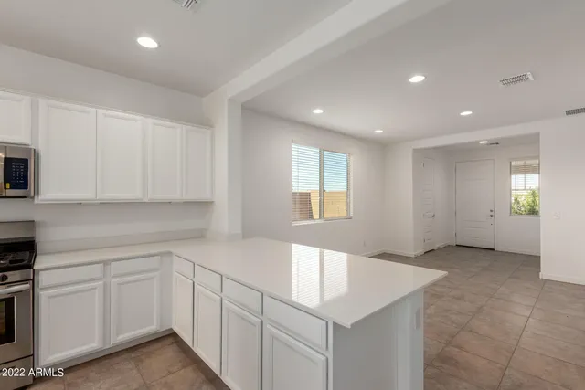 a white toilet sitting next to a white wall