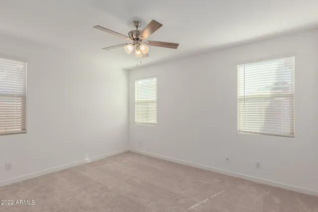 an empty room with closet and windows