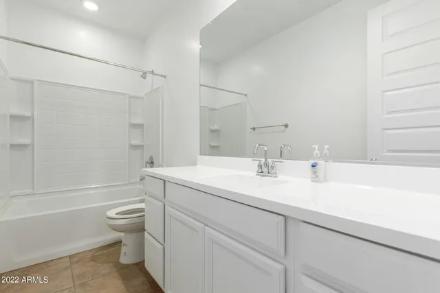 an empty room with closet and a ceiling fan