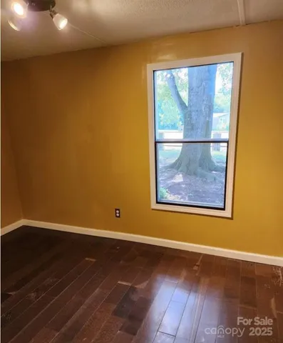 an empty room with wooden floor and a window