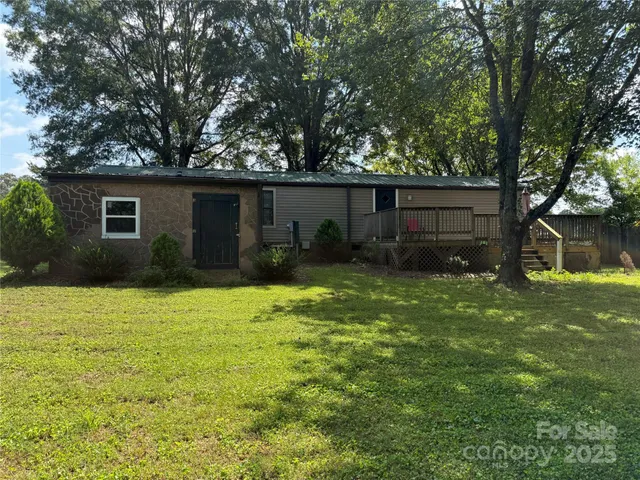 a backyard of a house with potted plants and large trees