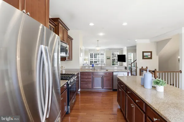 a kitchen with stainless steel appliances granite countertop a refrigerator and a stove