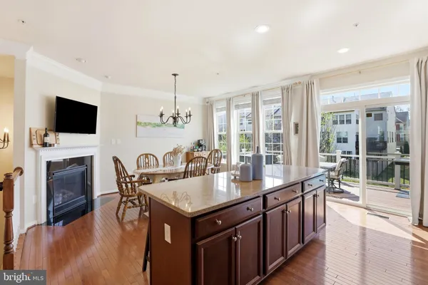 a kitchen with a stove a sink a dining table and chairs