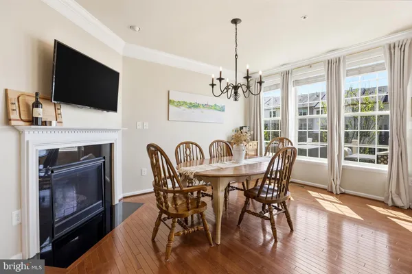 a view of a dining room with furniture wooden floor and a fireplace