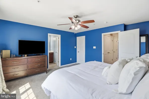 a bedroom with a bed and a flat tv screen on dresser