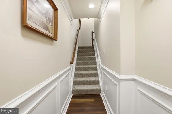 a view of staircase with wooden floor and white walls