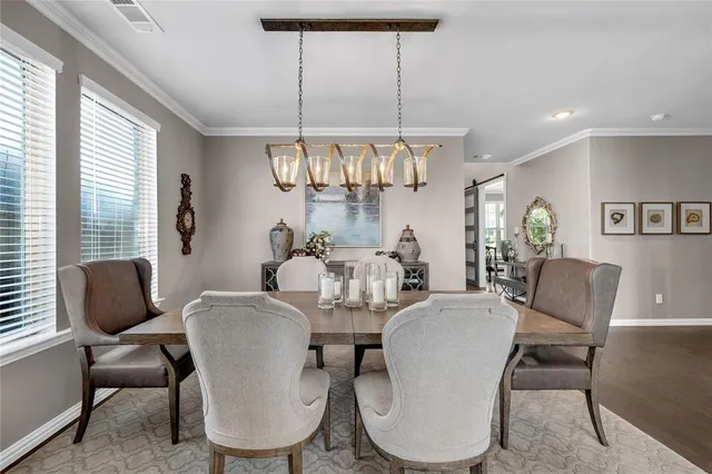 a dining room with furniture a chandelier and wooden floor