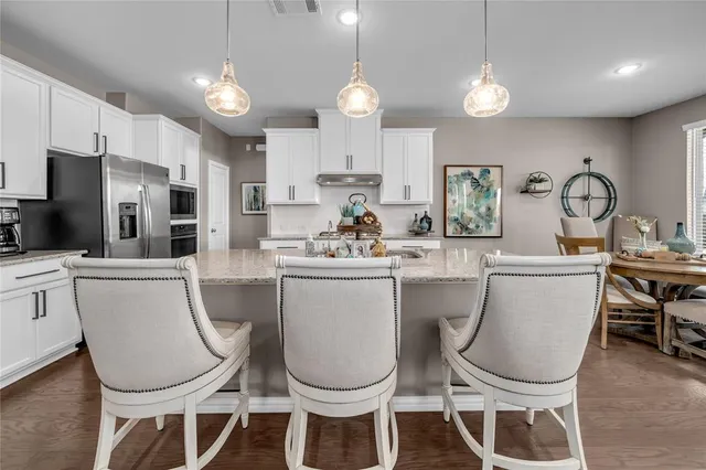 a kitchen with a dining table chairs sink and microwave