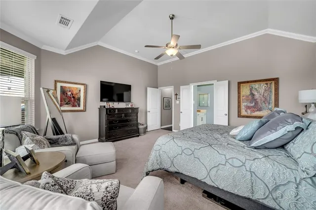 a bedroom with a bed couches and a flat tv screen