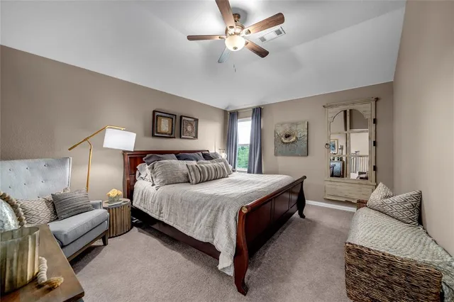a spacious bedroom with a bed and a chandelier