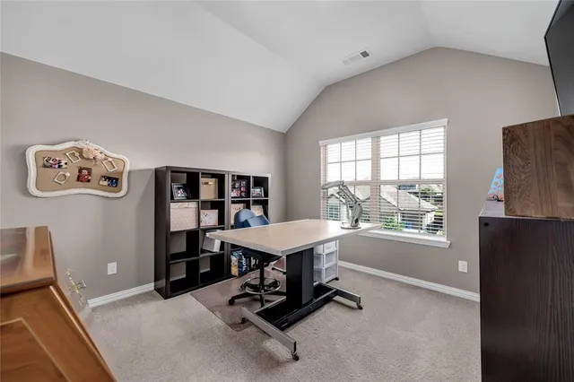 a view of a workspace with furniture and a window