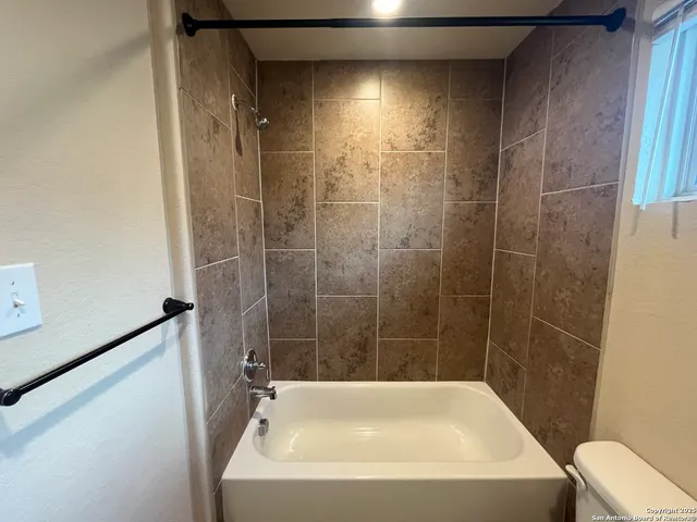 a bathroom with a toilet a sink and mirror