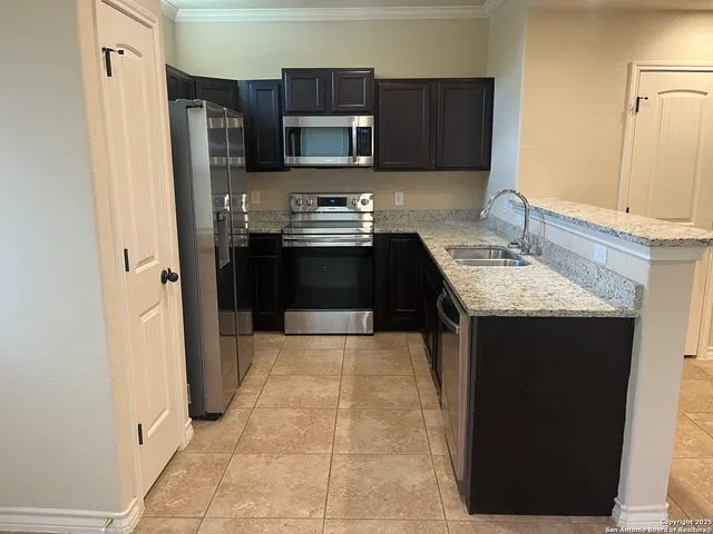 a kitchen with stainless steel appliances granite countertop a refrigerator and a stove top oven