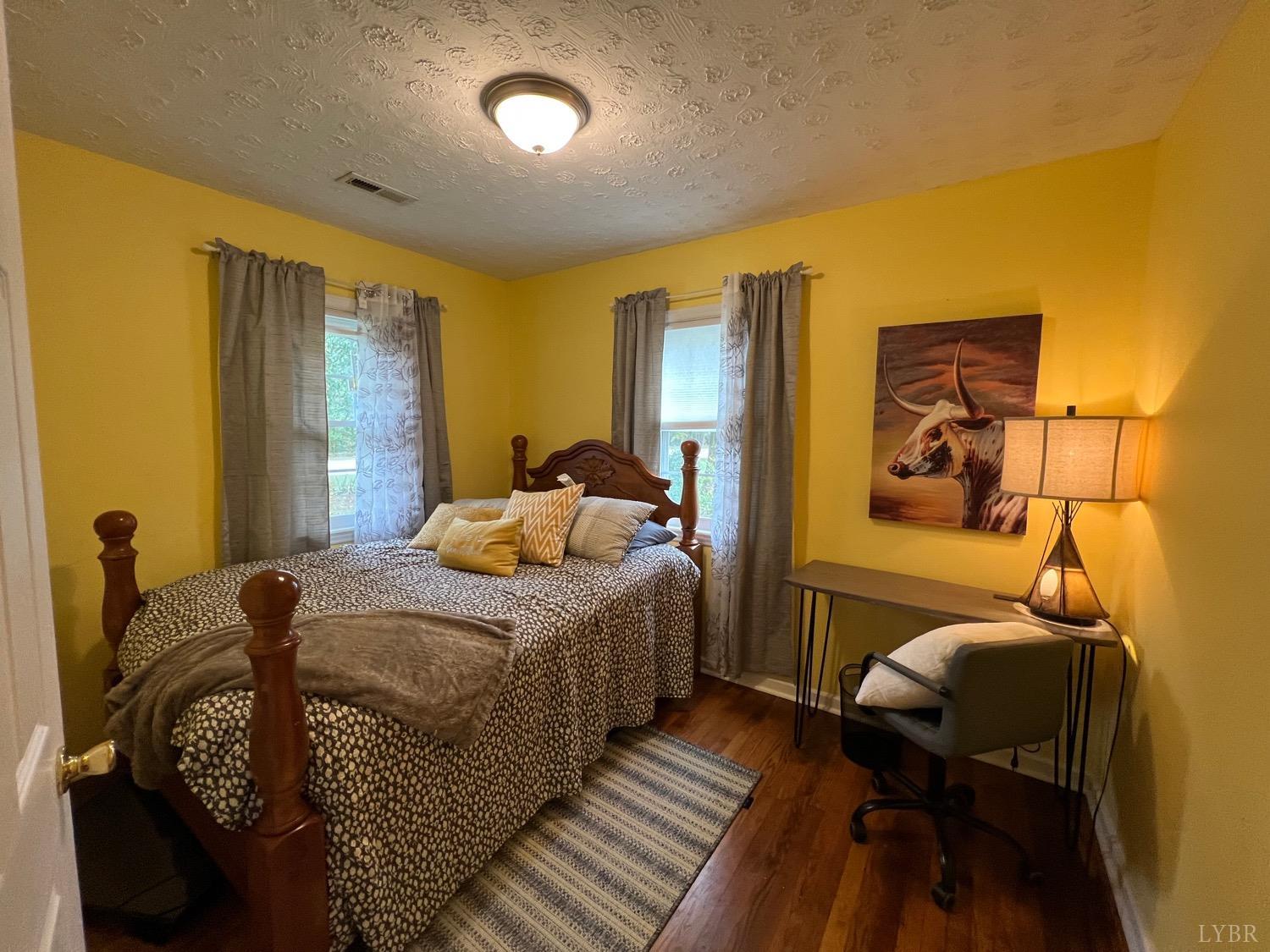 857 Woodson Road Roseland, VA 22967 - Photo 11 of 31 a bedroom with a bed and wooden floor