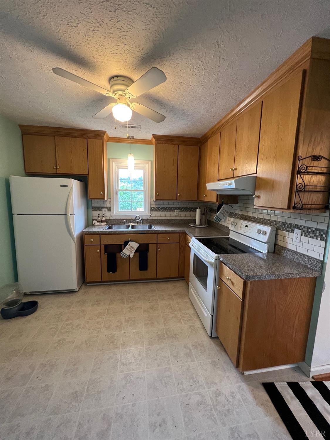 857 Woodson Road Roseland, VA 22967 - Photo 8 of 31 a kitchen with stainless steel appliances a stove a sink a microwave a refrigerator a center island and a window